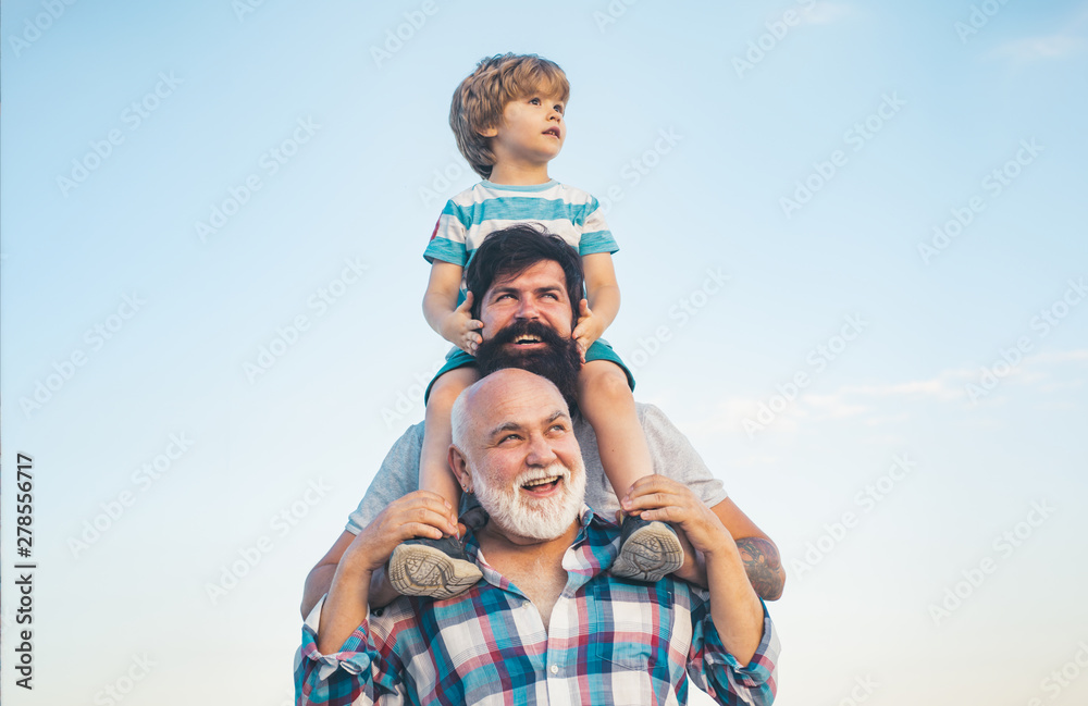 Men generation: grandfather father and grandson are hugging looking at camera and smiling. Fathers day concept. Generation concept. Weekend family play. Men in different ages. - obrazy, fototapety, plakaty 