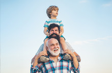 Men Generation: Grandfather Father And Grandson Are Hugging Looking At Camera And Smiling. Fathers Day Concept. Generation Concept. Weekend Family Play. Men In Different Ages.