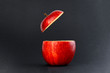 Health Red Cut Apple floating top slice juice drink idea concept on black background