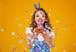 © JenkoAtaman - cheerful funny young woman with festive confetti on yellow .