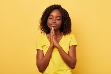 good looking woman with closed eyes keeping palms together and wising health and happiness to her family. meditation , lifestyle