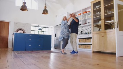 Wall Mural - Senior Couple At Home Dancing In Kitchen Together