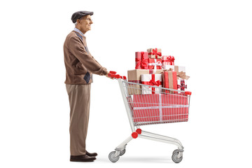 Elderly man standing with a shopping cart full of presents