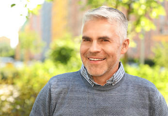 Wall Mural - Portrait of handsome mature man in park. Space for text