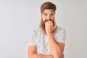 Wall Mural - Young redhead irish man wearing polo standing over isolated white background looking stressed and nervous with hands on mouth biting nails. Anxiety problem.