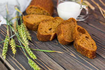 Freshness homemade bread with cup of milk on wooden background. Healthy organic food concept