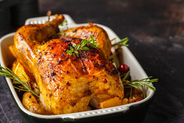 Wall Mural - Baked chicken with spices, cranberries, orange and onions in a glass dish.