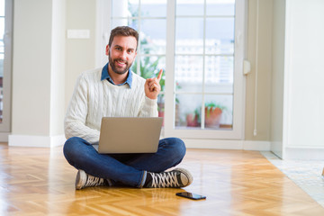 Wall Mural - Handsome man wearing working using computer laptop very happy pointing with hand and finger to the side