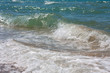 Moving sea waves breaking against sandy shore