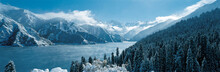 Snow Covered Trees And Mountains Surrounding Lake