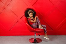 Young Girl Poses In Red Themed Setting