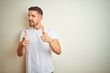 © Krakenimages.com - Young handsome man wearing casual white t-shirt over isolated background pointing fingers to camera with happy and funny face. Good energy and vibes.