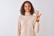 © Krakenimages.com - Young brazilian woman wearing turtleneck sweater standing over isolated white background showing and pointing up with fingers number four while smiling confident and happy.