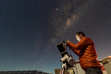 One Astronomer Man Looking The Night Sky Through An Amateur Telescope And Taking Photos With The Milky Way Rising Over The Horizon, An Amazing Night View At Atacama Desert