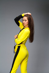 Sticker - Portrait of a young beautiful brunette woman in yellow tracksuit