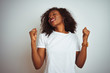 Leinwandbild Motiv Young african american woman wearing t-shirt standing over isolated white background celebrating surprised and amazed for success with arms raised and eyes closed. Winner concept.