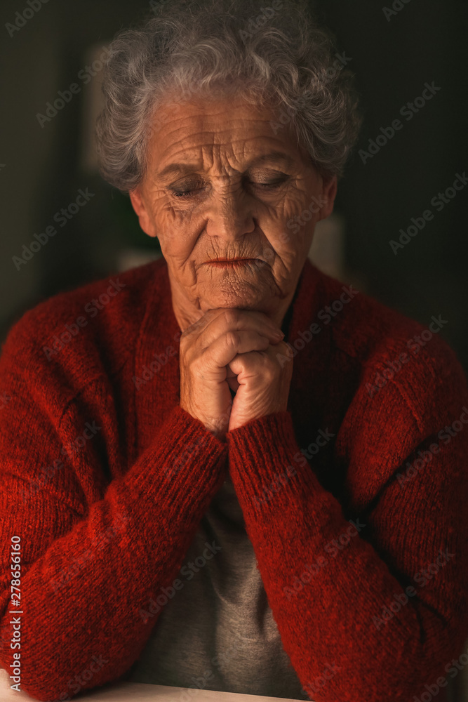 Senior woman praying to God at night