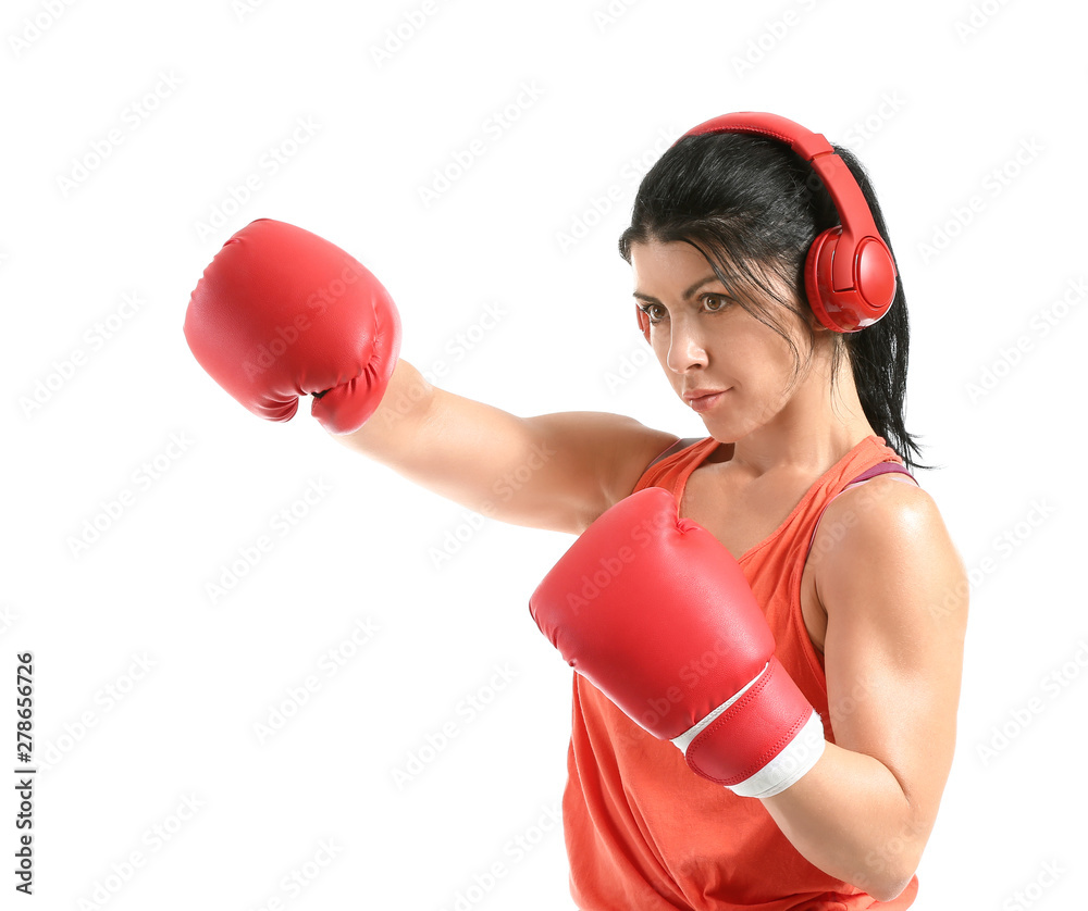 Sporty female boxer with headphones on white background