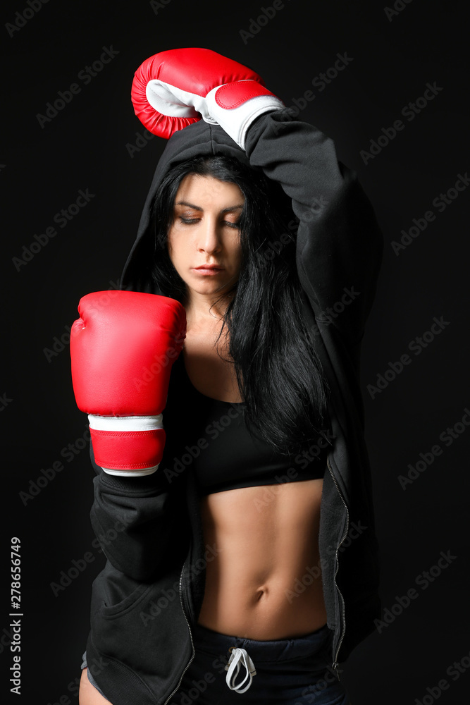 Sporty female boxer on dark background