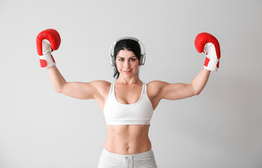 Sticker - Sporty female boxer with headphones on white background