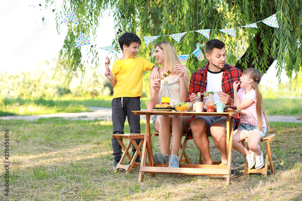 Happy family having picnic on summer day