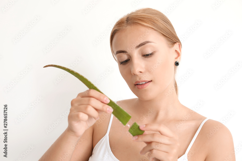 Beautiful young woman with aloe vera on white background