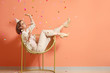 © Pixel-Shot - Happy woman with party whistle and glass of champagne near color wall