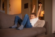 © HD92 - one boy happy with arms raised up in air, sitting in couch, relaxing in his home.