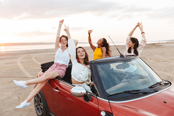 Sticker - Pretty happy smiling cheery young pretty women friends driving the car.