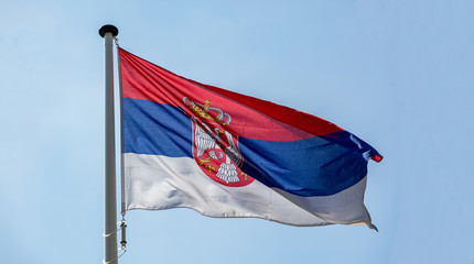 Serbian flag waving against clear blue sky