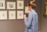 Fototapeta Maki - woman visitor in historical museum looking at pictures