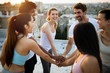 © NDABCREATIVITY - Group of young happy people friends exercising outdoors at sunset.