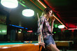 © NDABCREATIVITY - Young beautiful woman having fun and playing billiard in a club