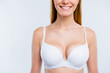 Cropped close-up portrait of nice confident attractive lovely cheerful cheery blonde girl chest after uplift injection wearing bra isolated over light gray background