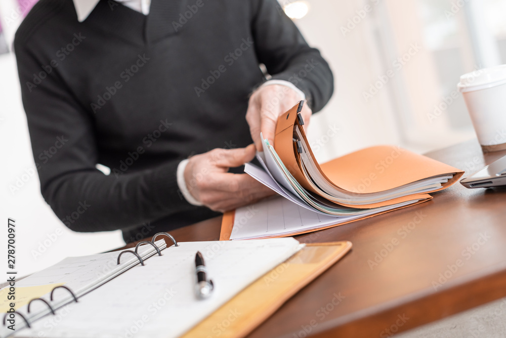 Businessman looking for document in folder - obrazy, fototapety, plakaty 
