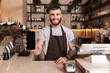 © Drobot Dean - Smiling attractive man barista standing