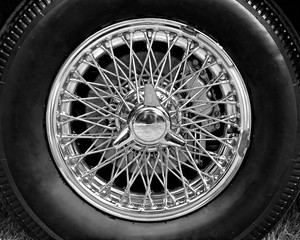 Closeup of vintage car wire wheel in black and white