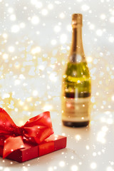 Wall Mural - New Years Eve holiday champagne bottle and a gift box and shiny snow on marble background