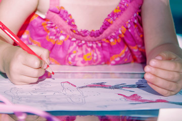 Llittle female artist designer draws a pencil sketch  on notebook (creativity, art, training concept)