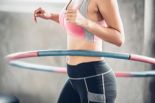 Asian Woman Excercise With Hula Hoop In The Gym.