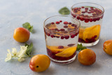 Fototapeta Kuchnia - Fresh cool detox drink with berries and peaches or aprikotes.