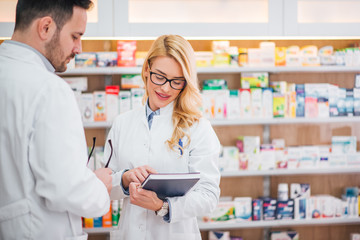 Two pharmacist working in drugstore.