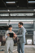© bnenin - Executive manager talking to a female factory employee at manufacturing plant.