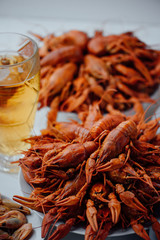 two large plates with boiled crayfish, boiled shrimps and beer