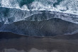 Aerial view of Atlantic ocean waves washing black sandy beach