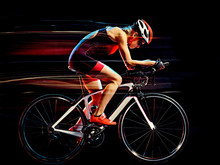 One Caucasian Woman Triathlon Triathlete Cyclist Cycling Studio Shot Isolated On Black Background With Light Painting Effect