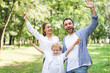 © LIGHTFIELD STUDIOS - excited family with outstretched hands looking at camera in park