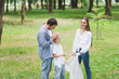 © LIGHTFIELD STUDIOS - family in casual clothes picking up garbage in plastic bag in park