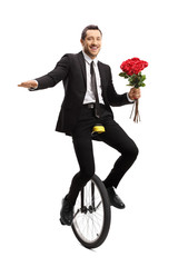 Sticker - Young businessman riding a unicycle and holding a bouquet of red roses