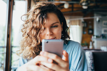 Close-up Portrait Of Young Woman Texting On Smart Phone